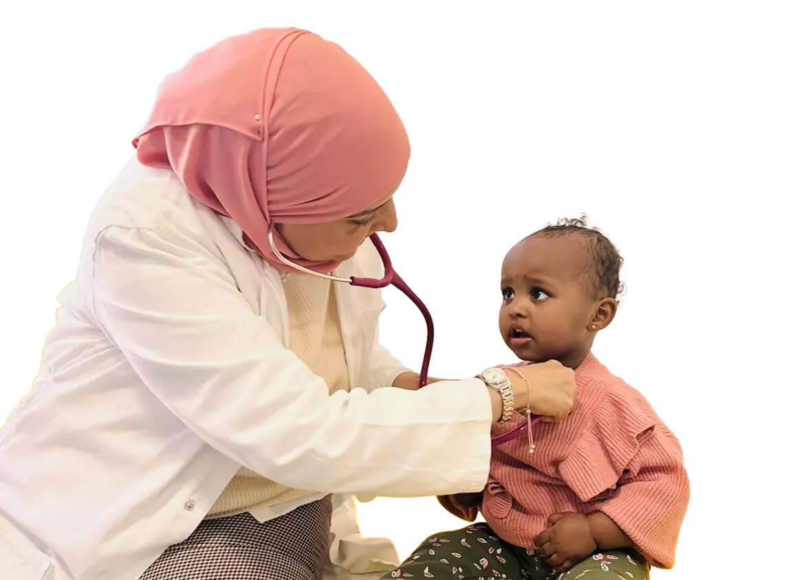 Eine medizinische Fachkraft untersucht ein Kleinkind mit einem Stethoskop, beide sitzen vor einem schwarzen Hintergrund.